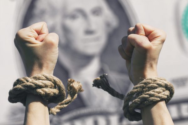 Financial freedom, hands broke fetters against the background of the dollar, close-up