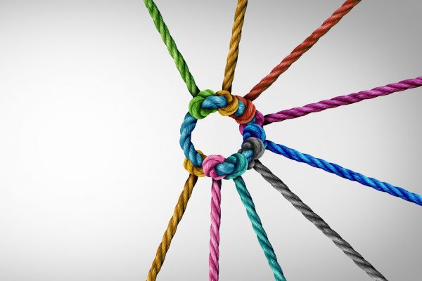 Unity and teamwork concept as a business metaphor for joining a partnership as diverse ropes connected together as a corporate symbol for cooperation and working collaboration.