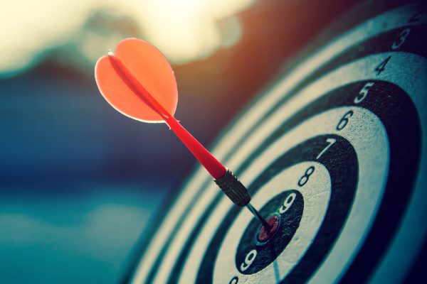 bullseye target or dart board has red dart arrow throw hitting the center of a shooting for business targeting and winning goals business concepts.